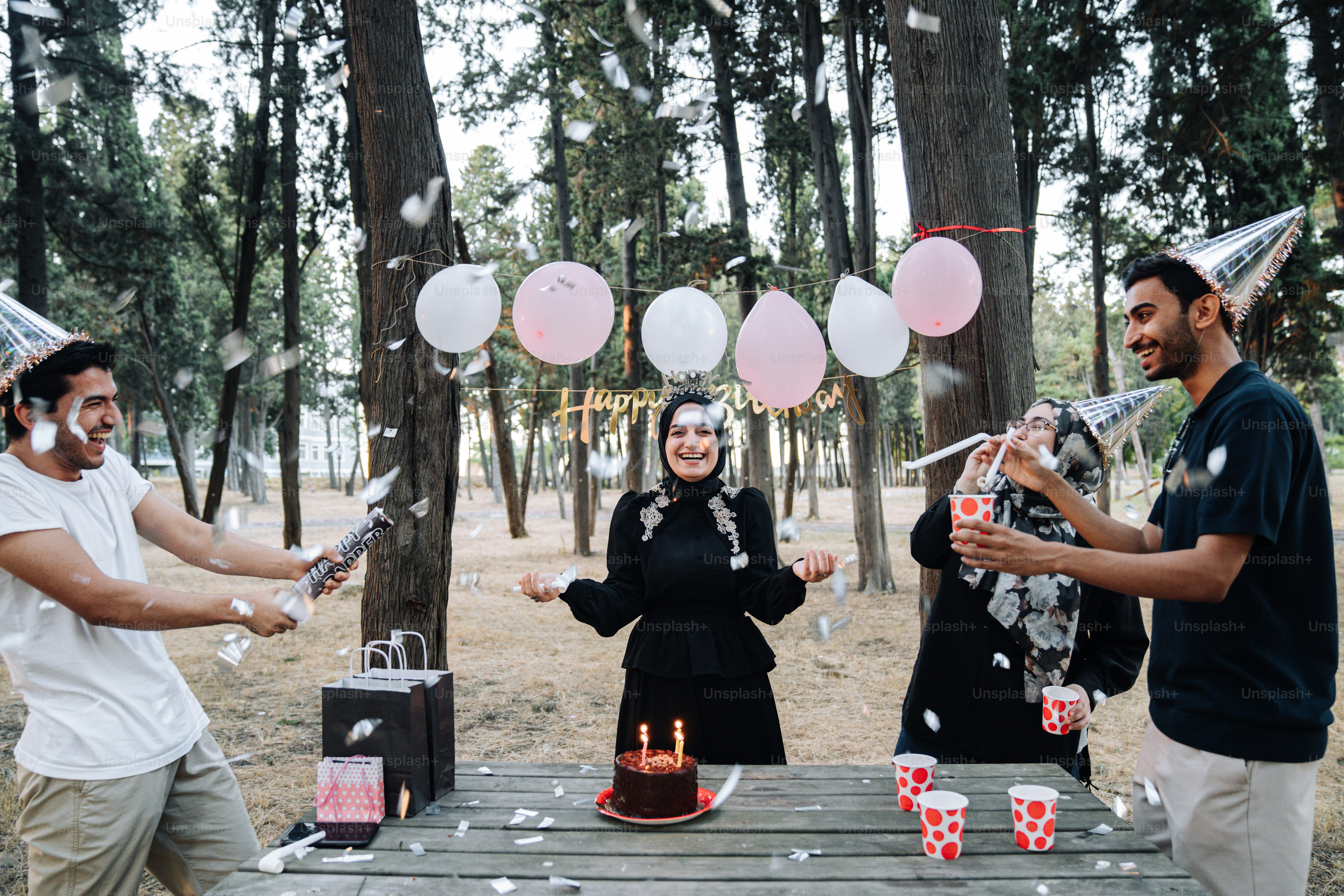 A group of people standing around a table with a cake photo – Birthday ...