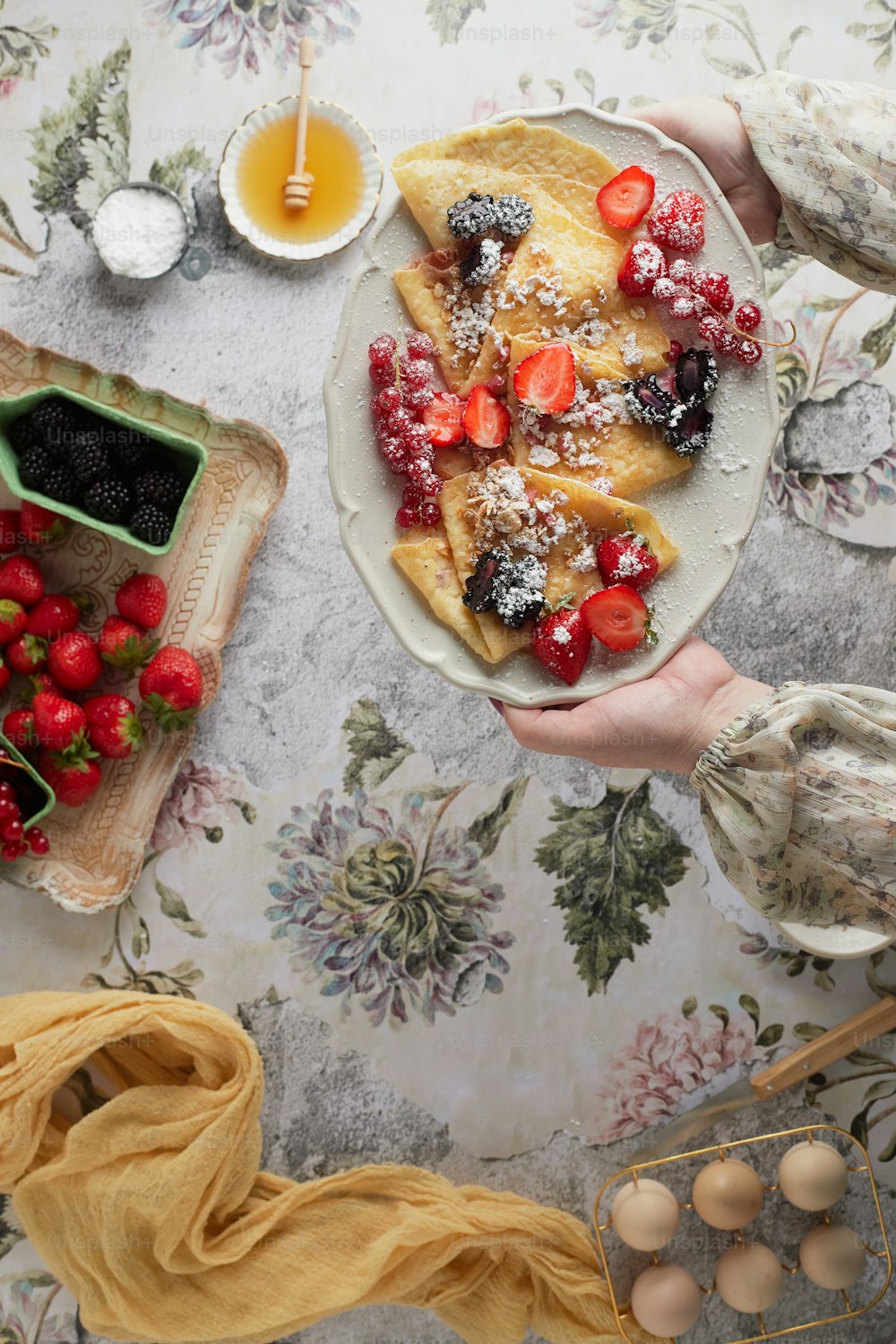 a person holding a plate of food on a table