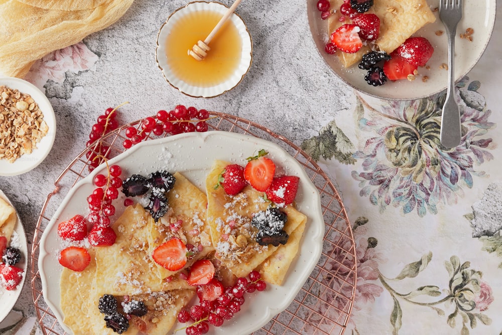 a white plate topped with crepes covered in fruit