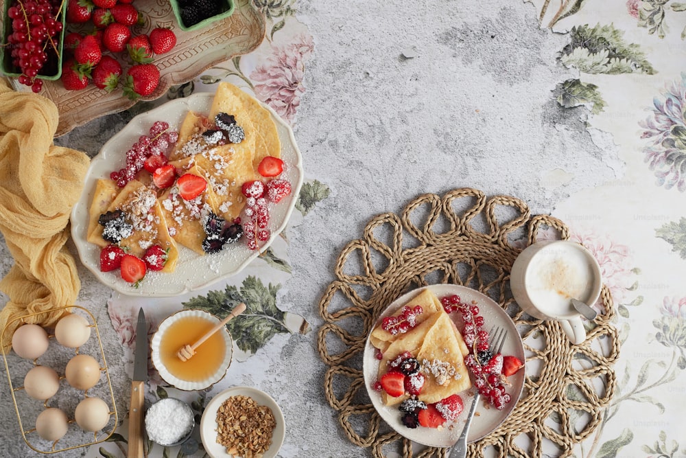 une table surmontée d’assiettes de nourriture à côté d’un bol de fruits