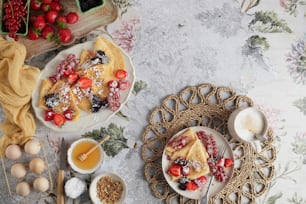 ein Tisch mit Tellern mit Essen neben einer Obstschale