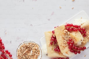 a white plate topped with food next to a bowl of granola