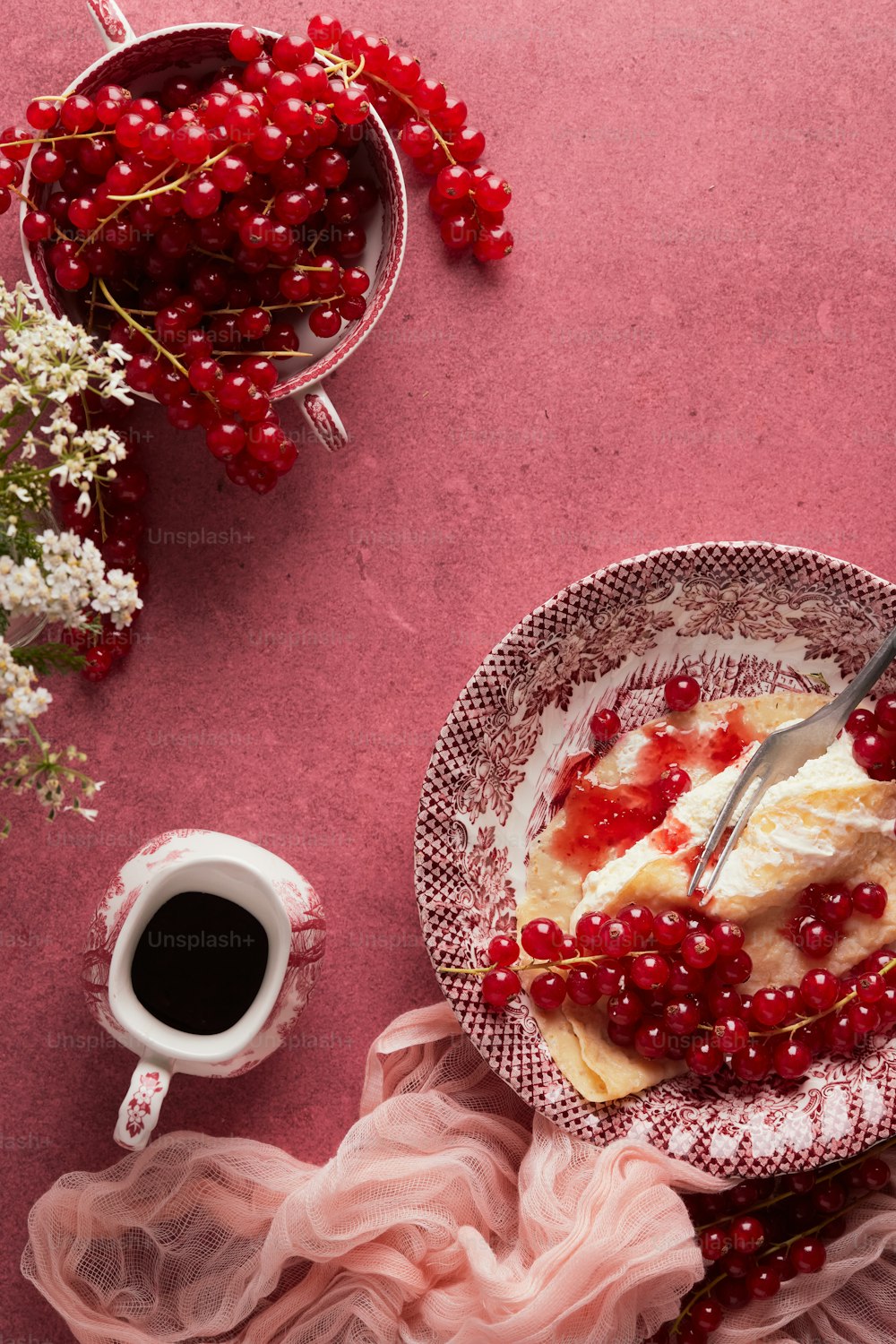 a plate of cake with cherries and a cup of coffee