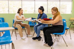a group of women sitting at a table in a classroom
