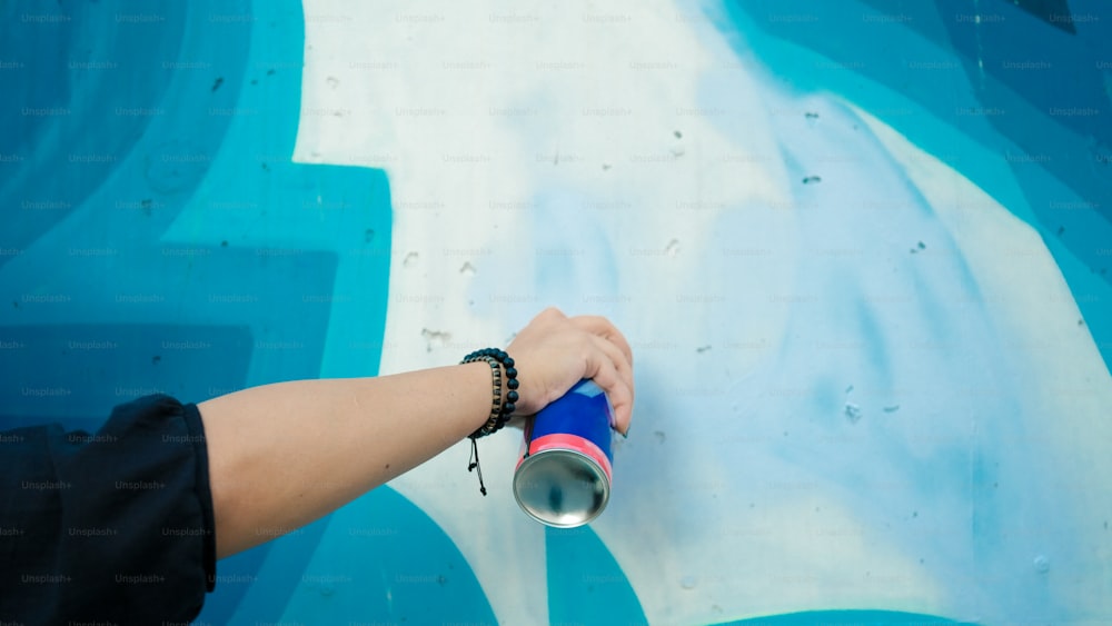 uma pessoa segurando um objeto azul e vermelho na mão