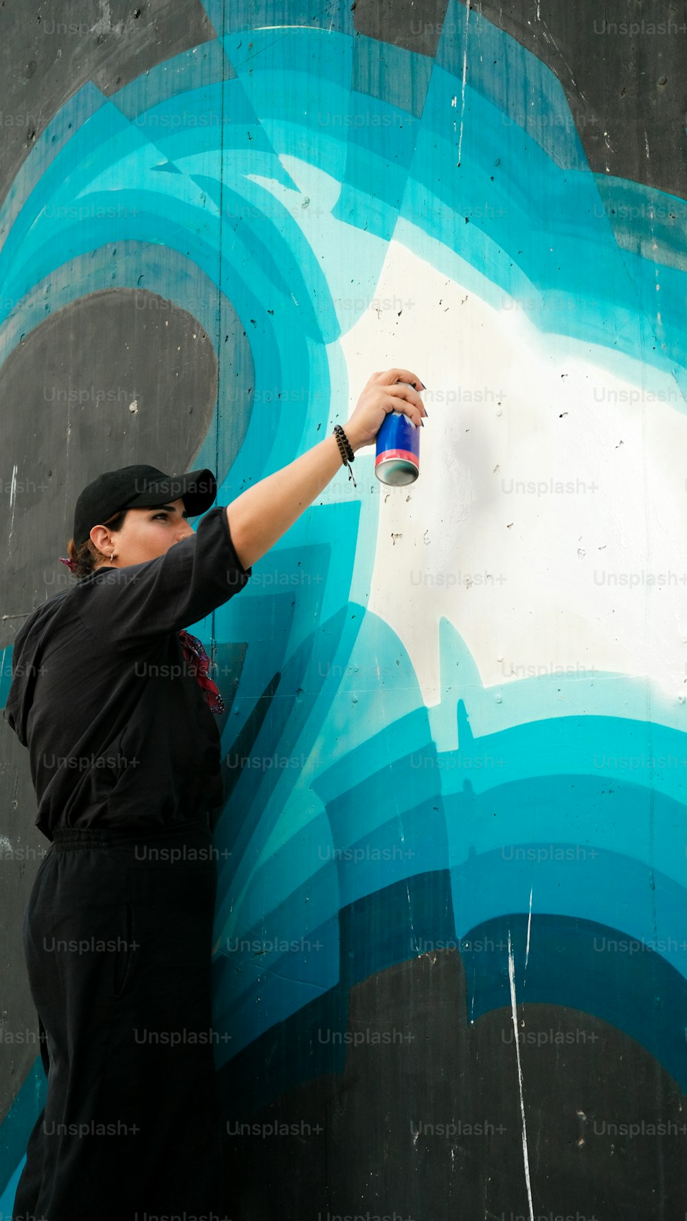 um homem spray pintando um mural em uma parede