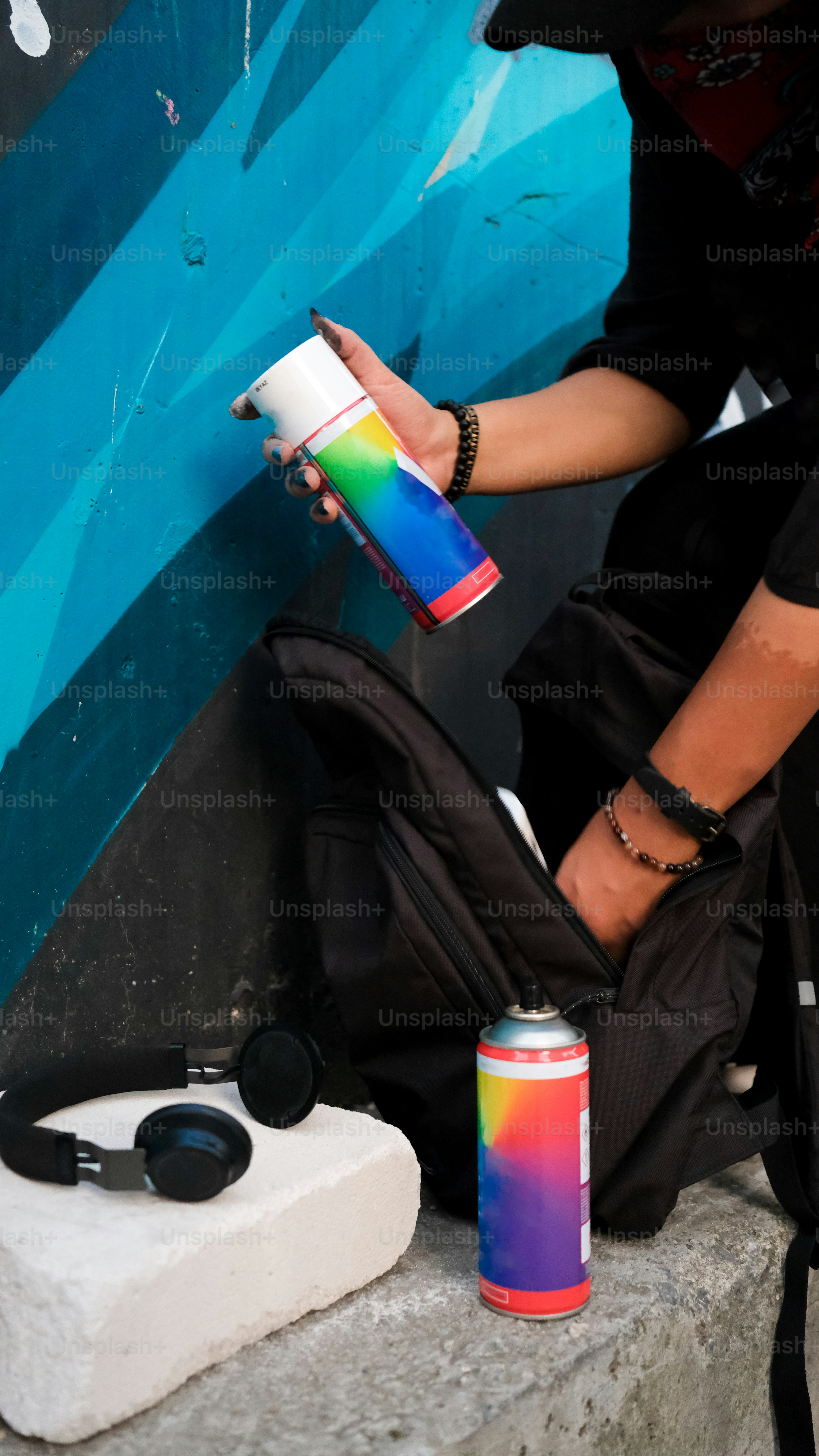 人がスプレー缶で壁を塗っている