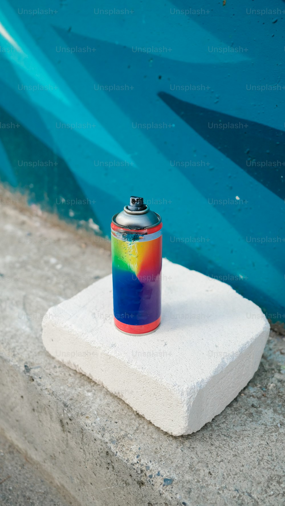 a can of soda sitting on top of a block of concrete