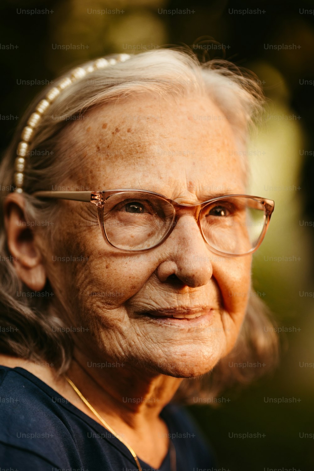 an old woman wearing glasses and a pearl necklace