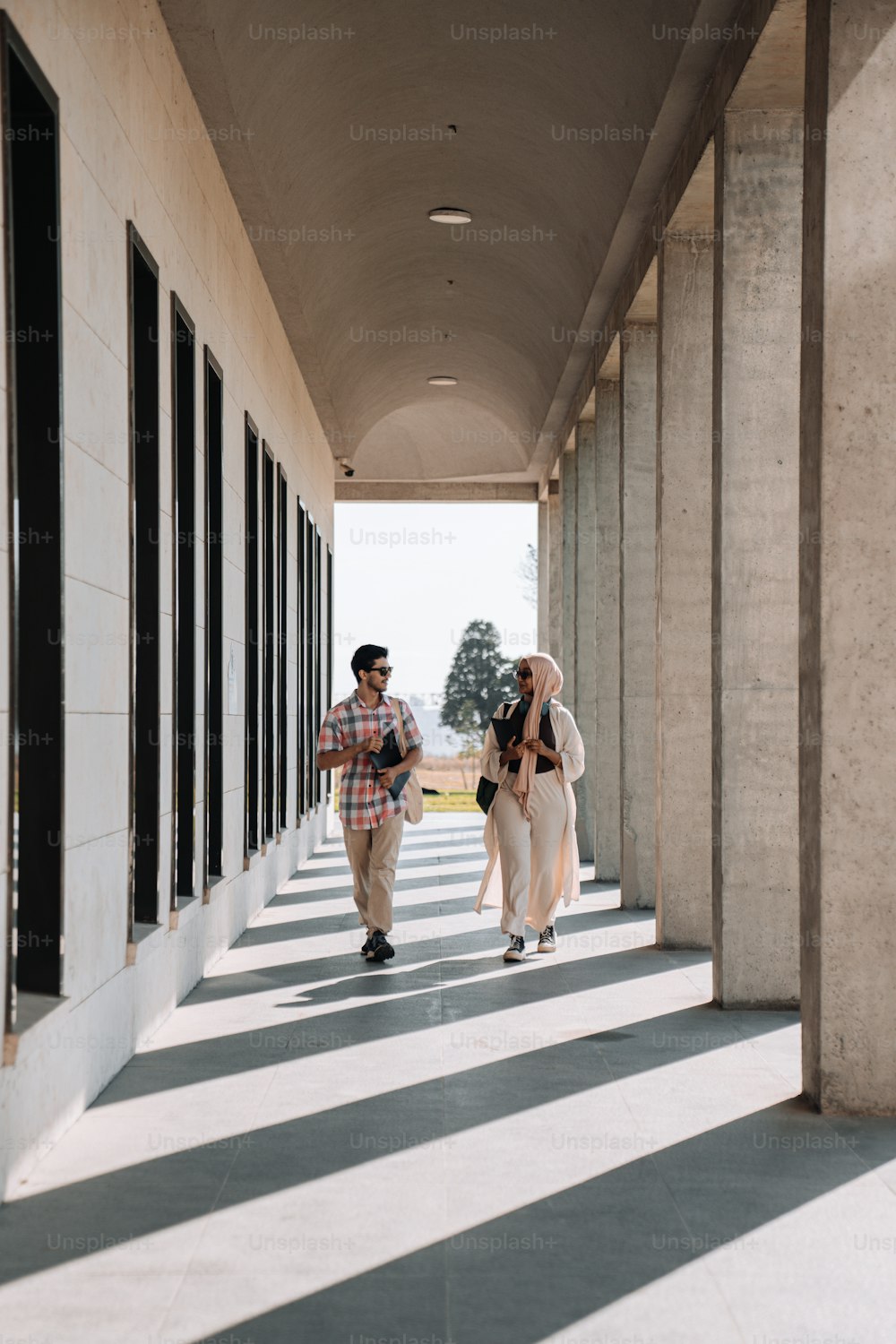 a couple of people that are walking down a hallway