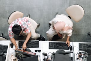 two men working on computers in an office