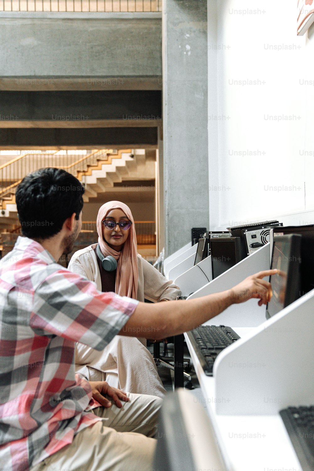 a man and a woman looking at a computer screen