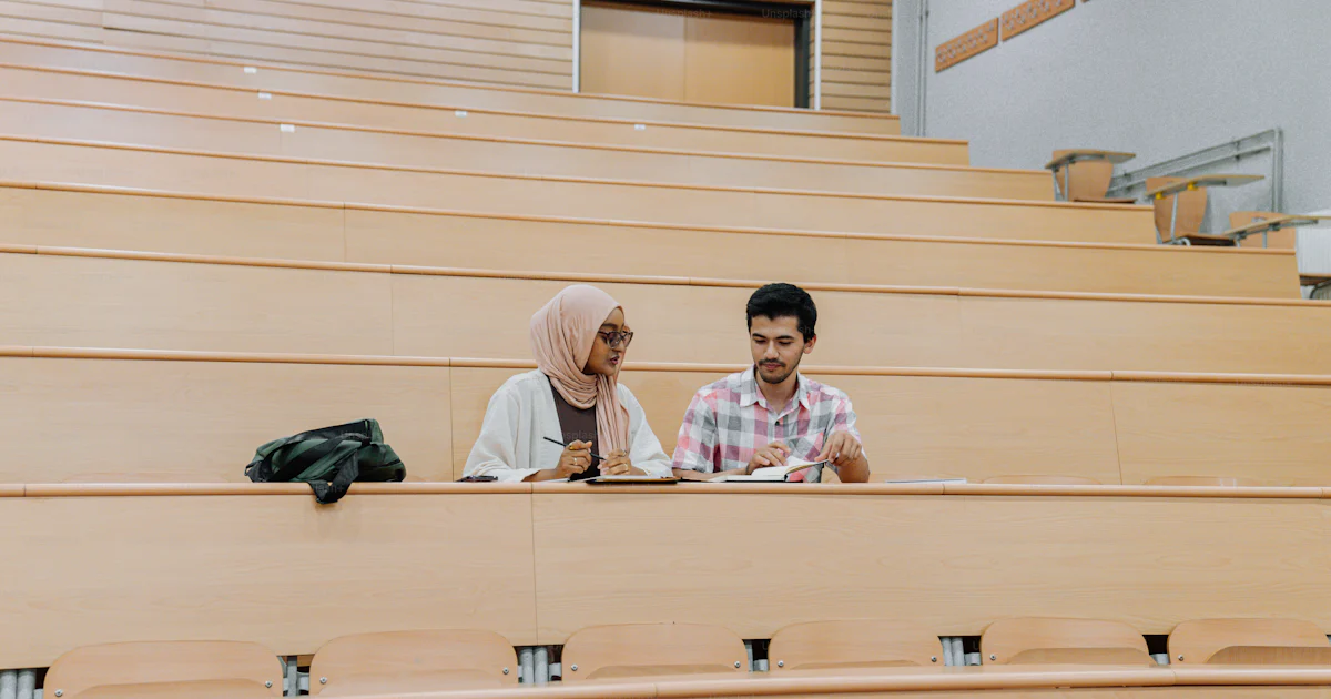 Lecture Study A man and a woman sitting in a lecture hall photo – Study Image on Unsplash