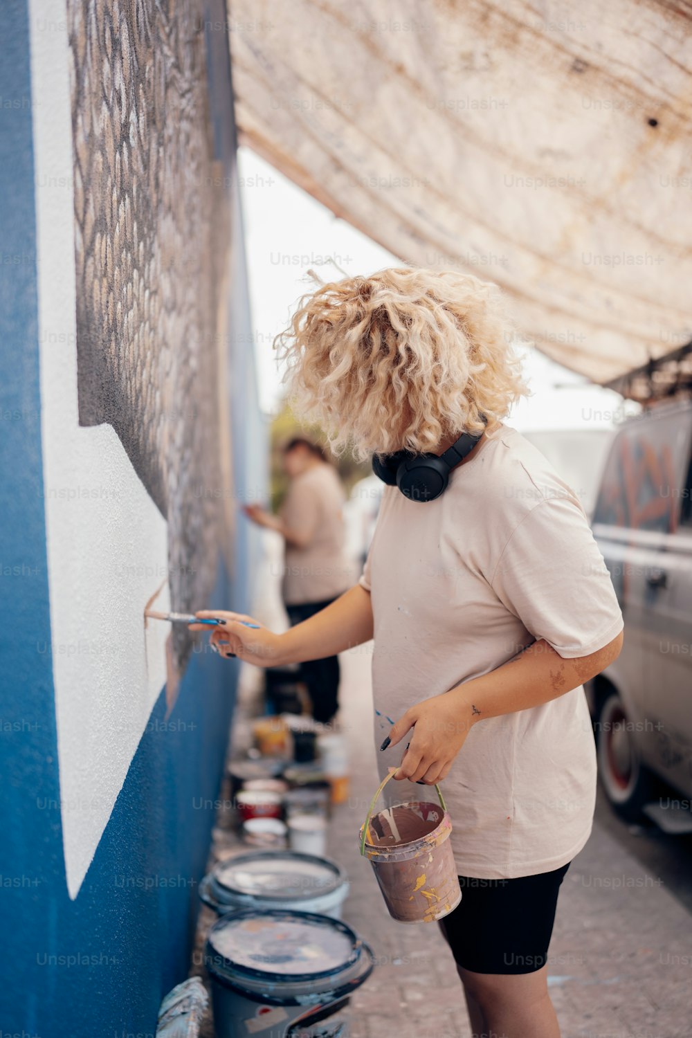 uma mulher pintando uma parede com tinta azul