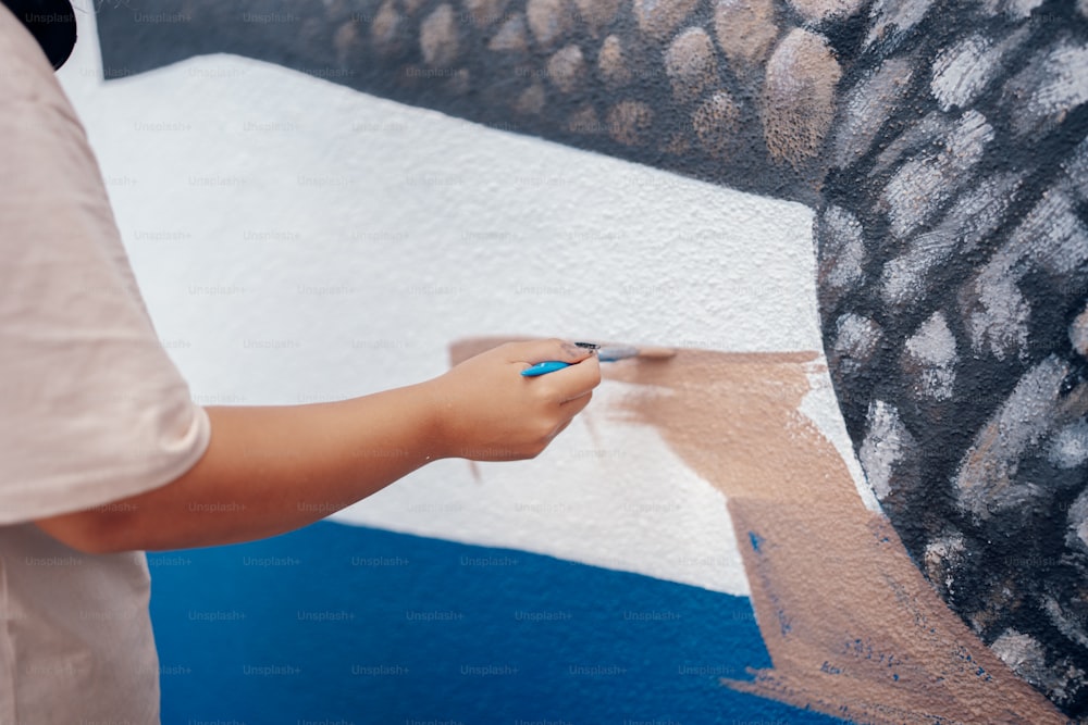 una persona sta dipingendo un quadro su un muro