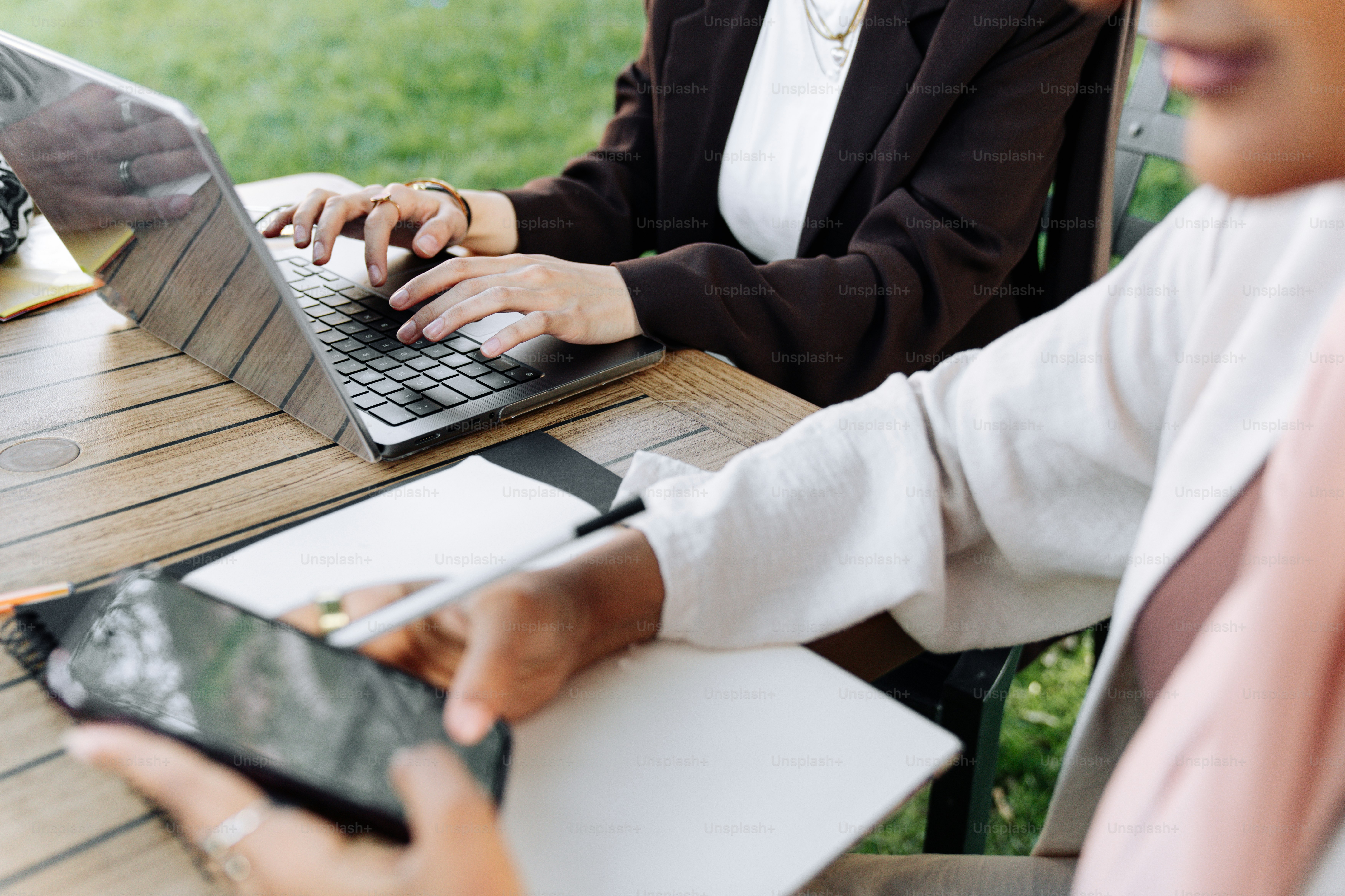 ノートパソコンを使ってテーブルに座る女性