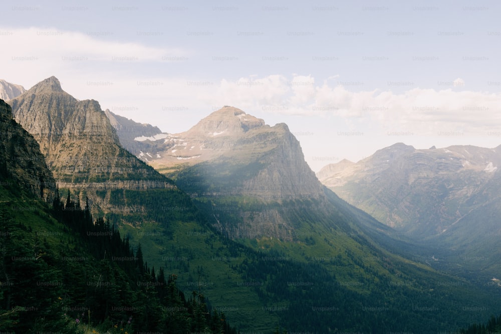 une vue d’une chaîne de montagnes avec des arbres et des montagnes en arrière-plan