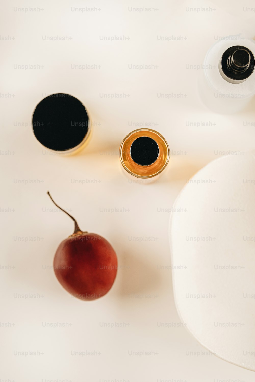 a white table topped with a cherry and a bottle of wine