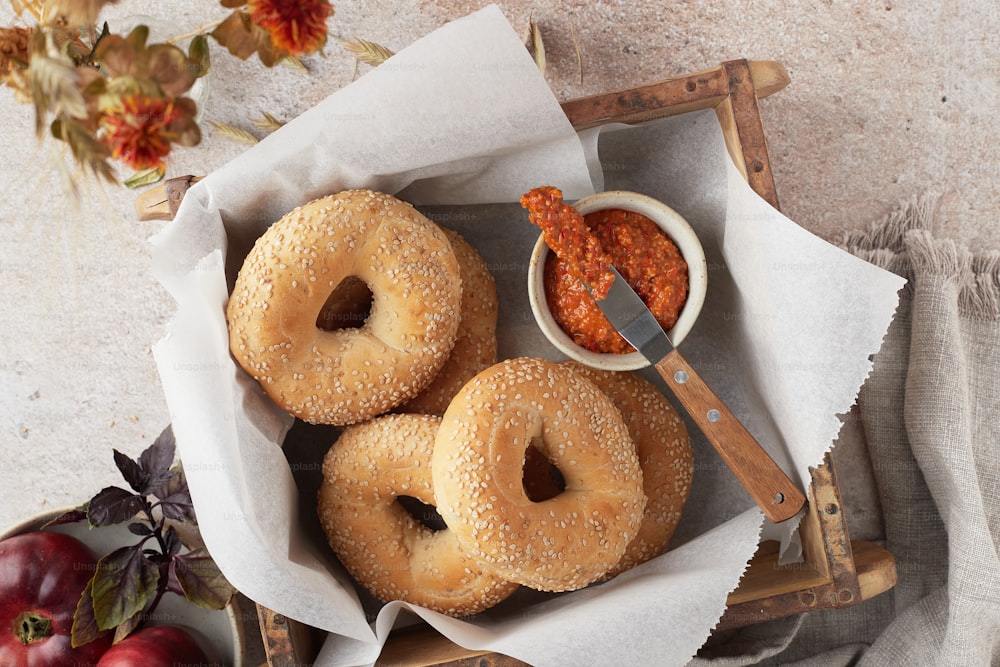 a basket filled with three bagels covered in sauce