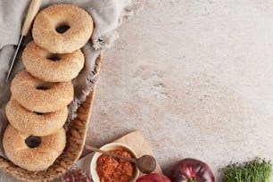 a basket filled with bagels next to a bowl of tomato sauce