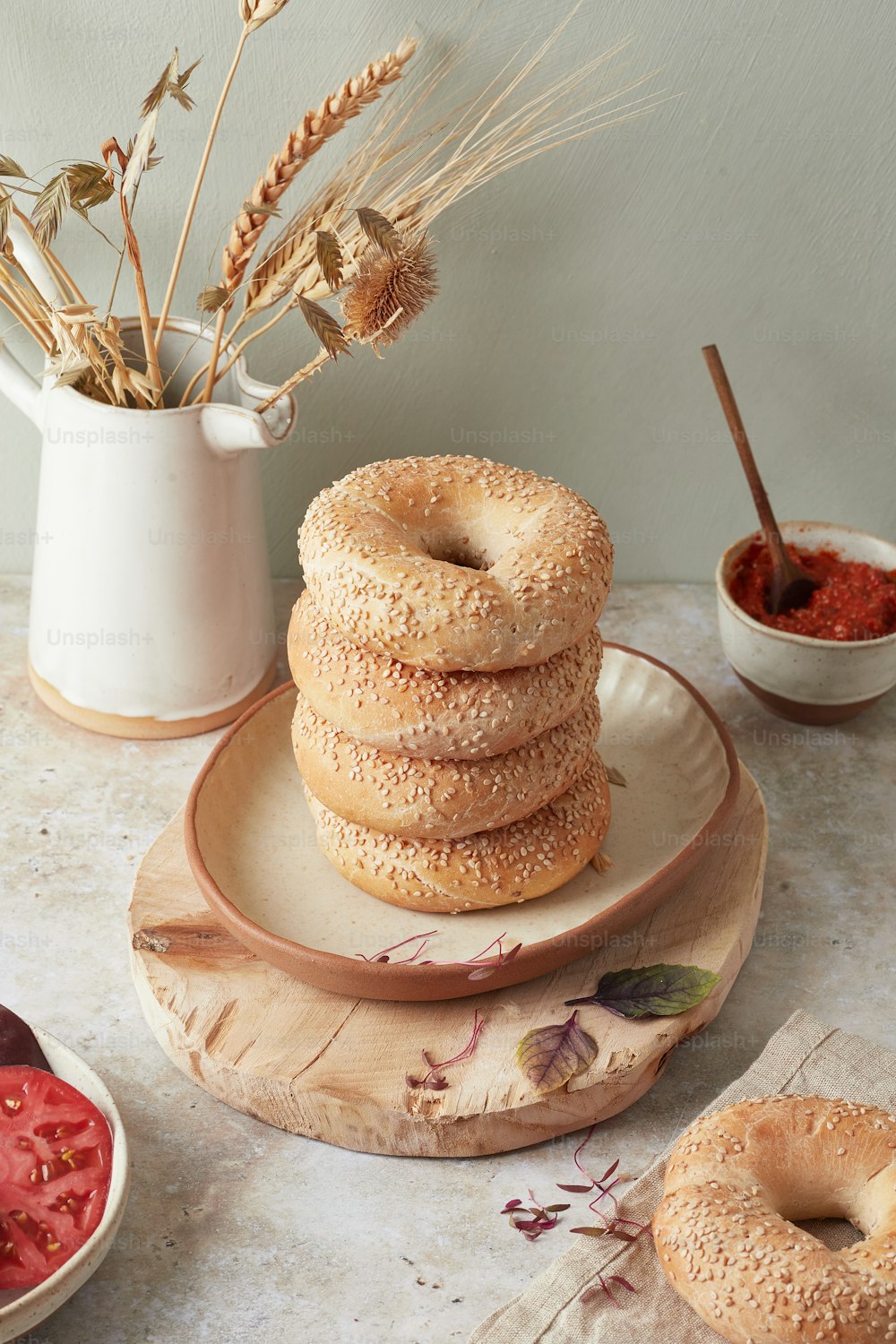 uma pilha de bagels sentada em cima de uma placa de madeira