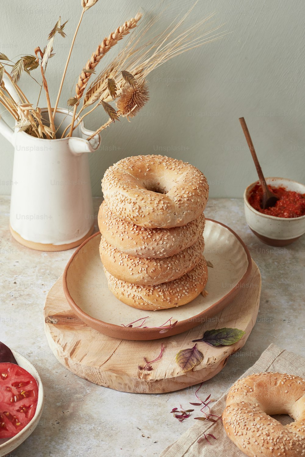 a stack of bagels sitting on top of a wooden plate
