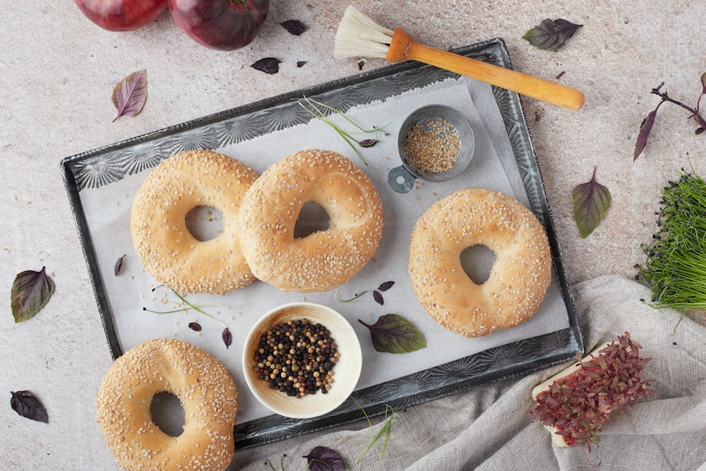 a tray with bagels and a bowl of seeds
