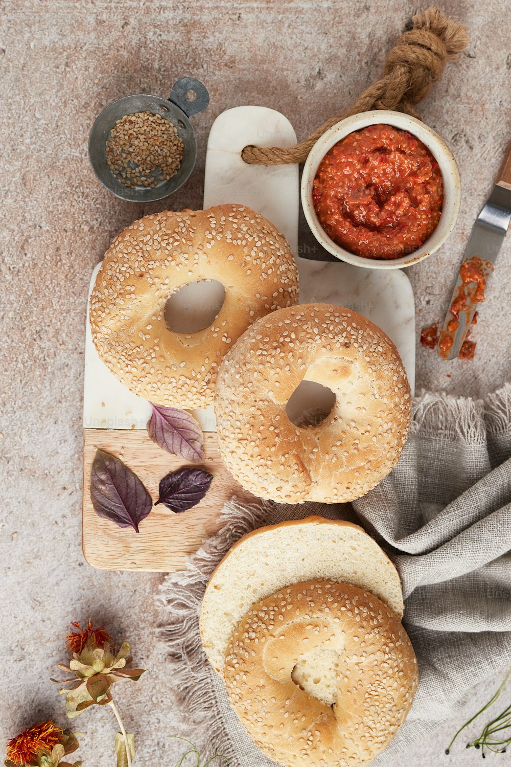 a table topped with bagels covered in sauce