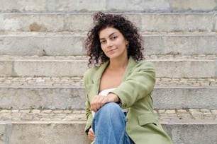 a woman sitting on some steps with her legs crossed