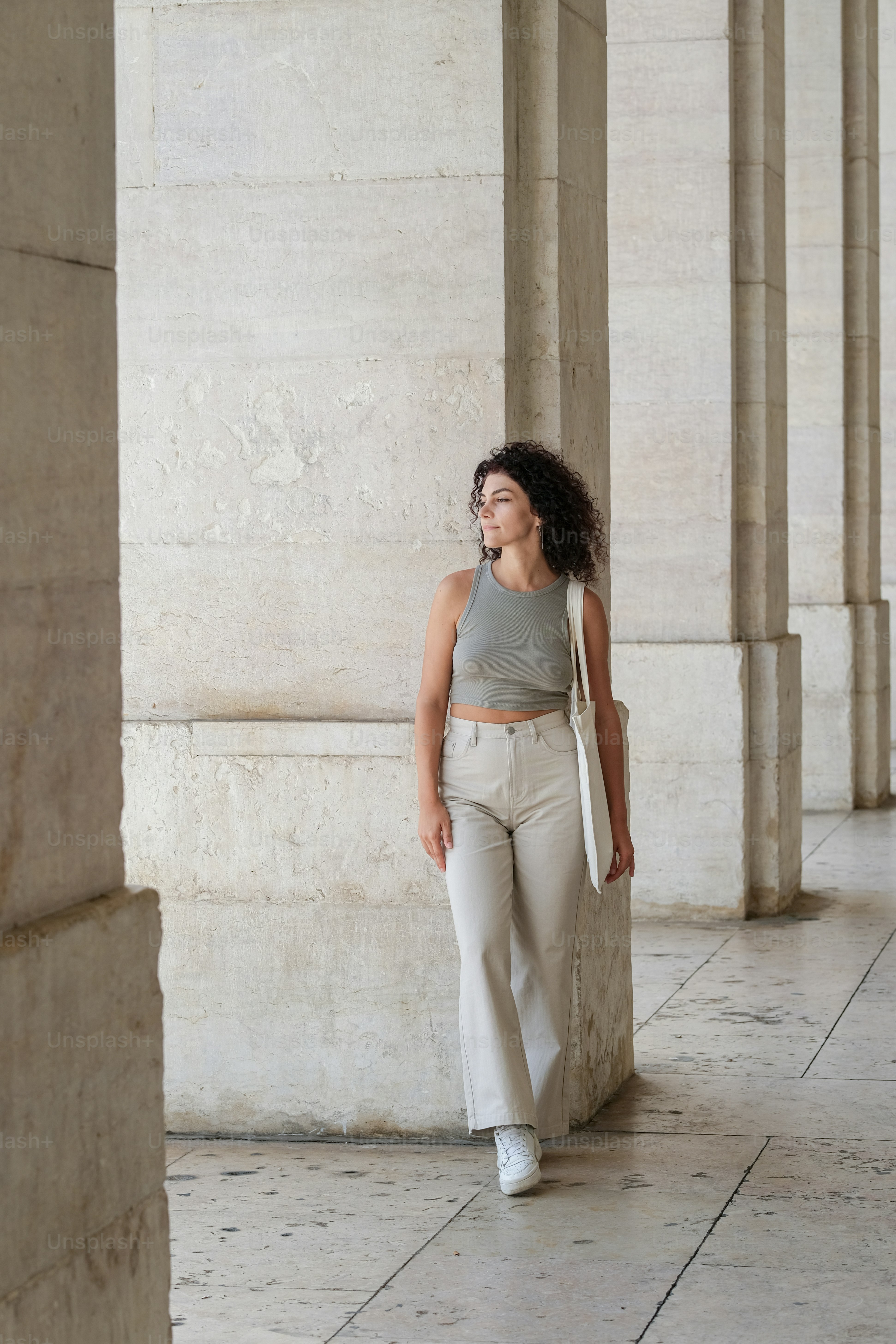 Una mujer de pie en una habitación con columnas