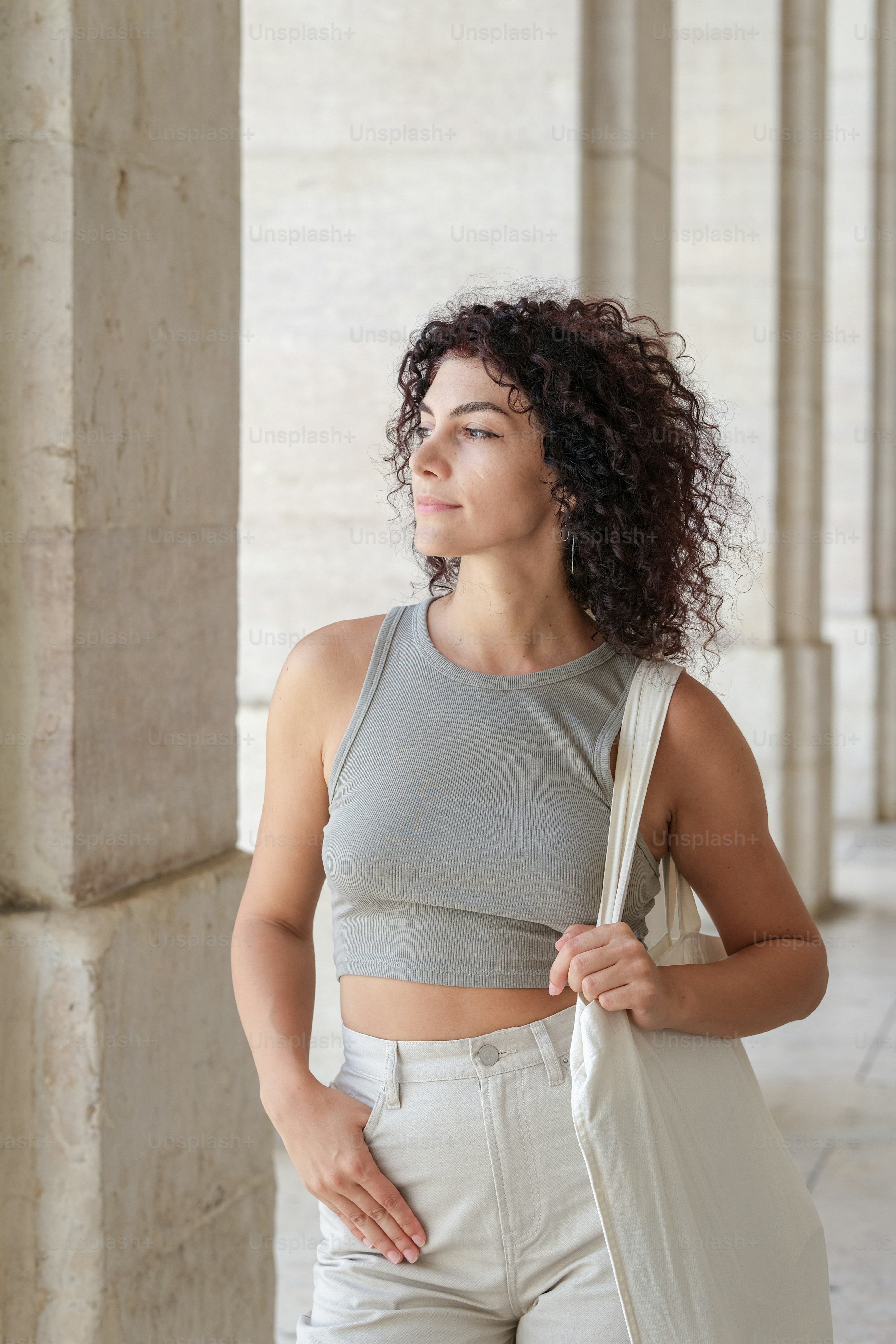 uma mulher com cabelo cacheado está segurando uma bolsa