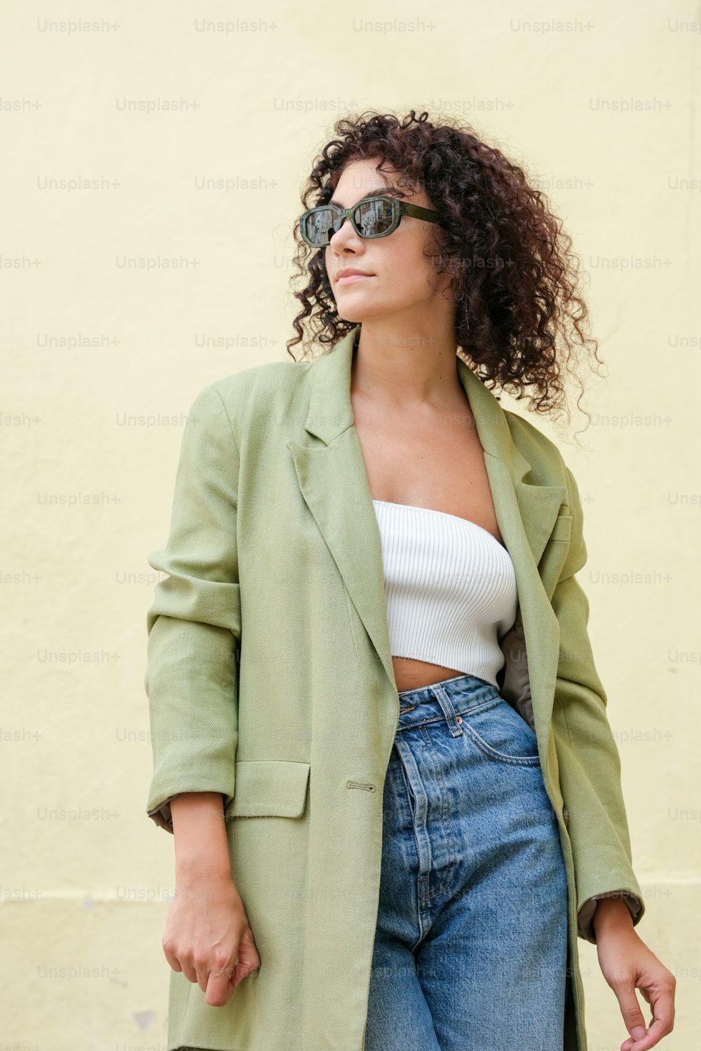Eine Frau, die einen grünen Mantel und eine Sonnenbrille trägt