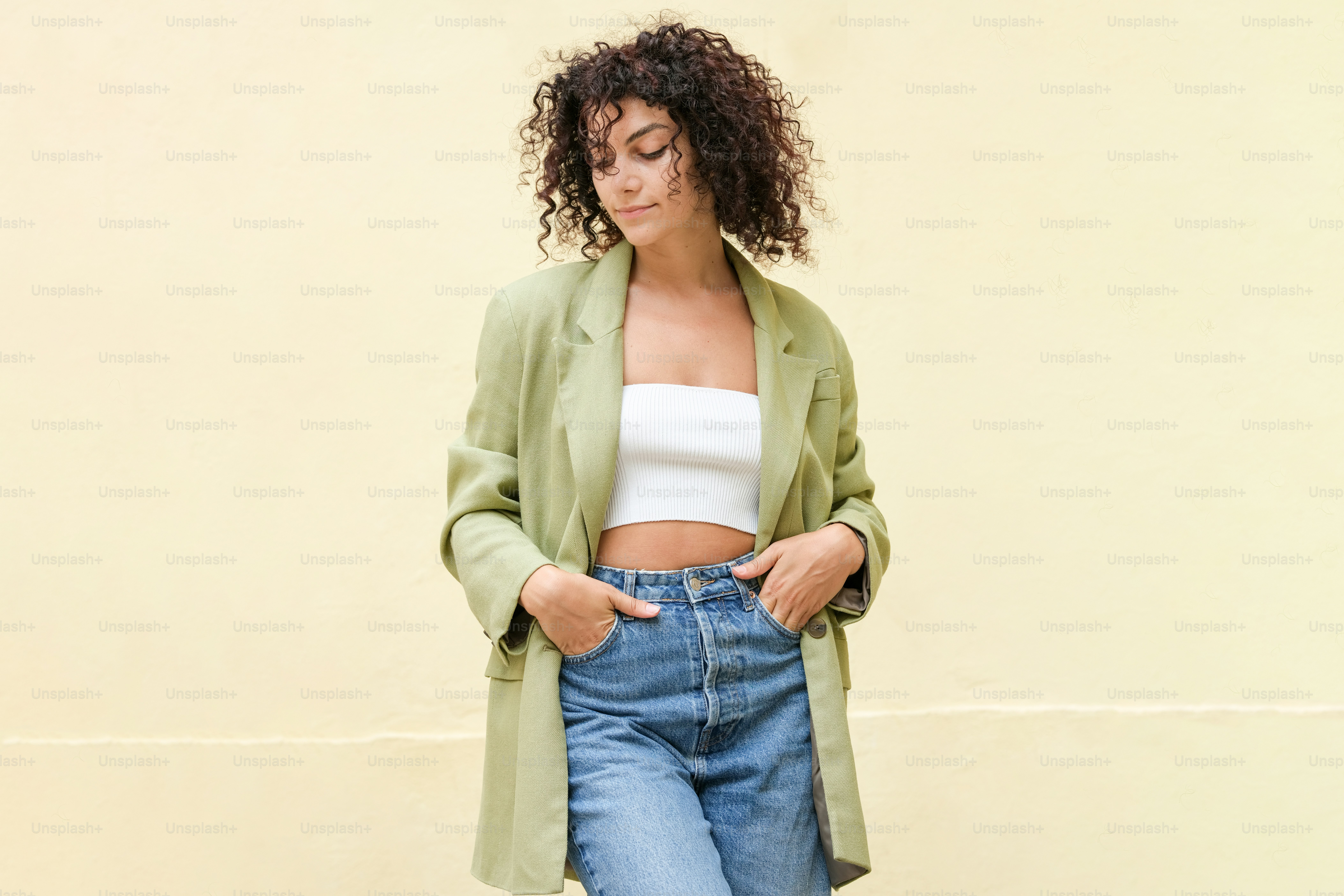 a woman standing in front of a yellow wall