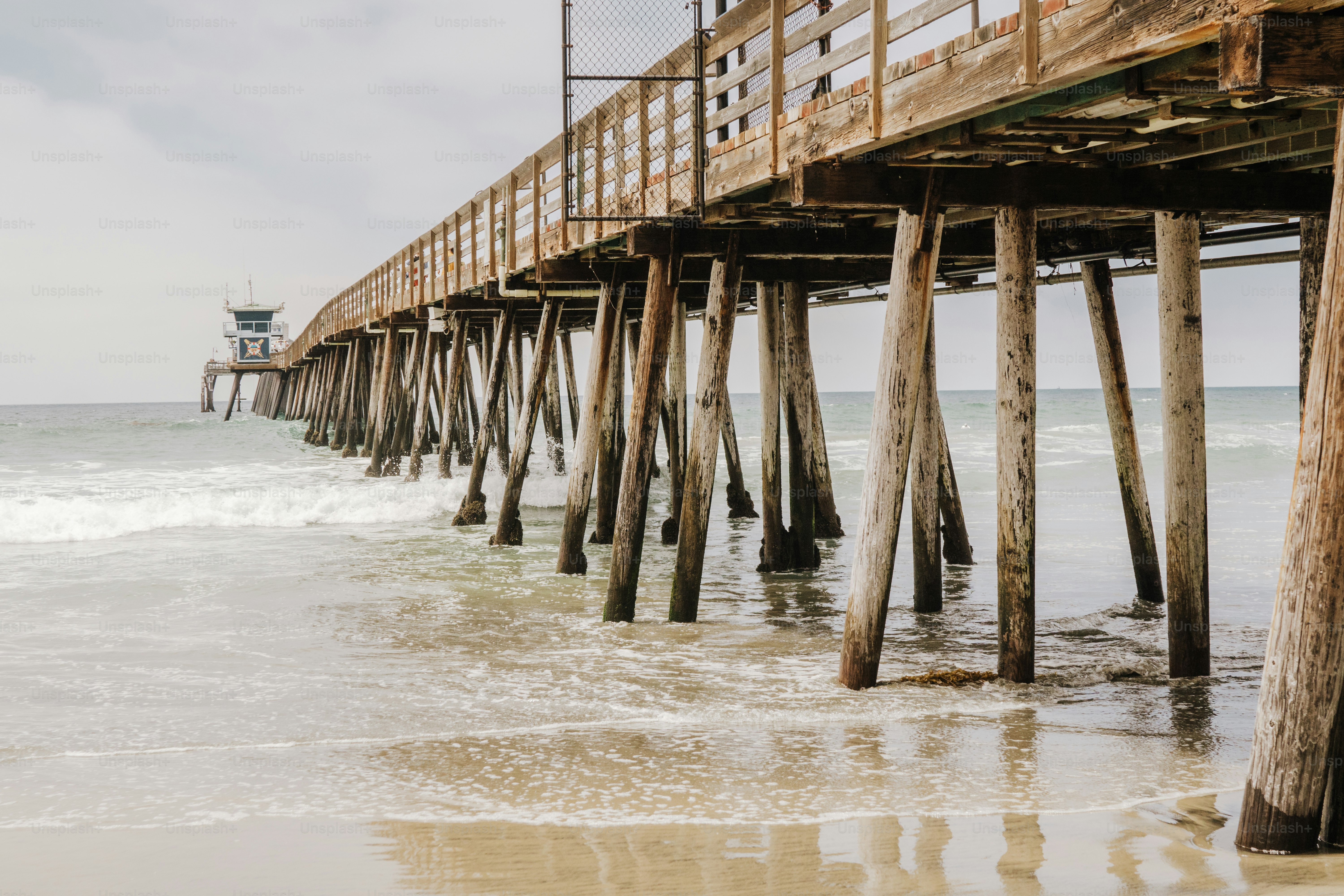a long wooden pier stretches out into the ocean