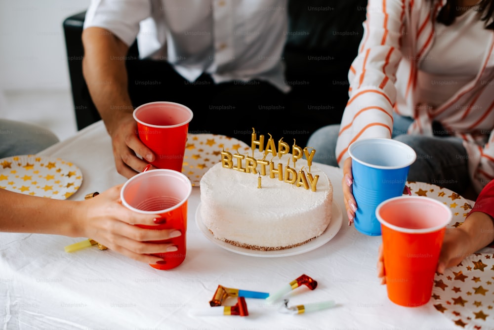 Un grupo de personas sentadas alrededor de una mesa con un pastel