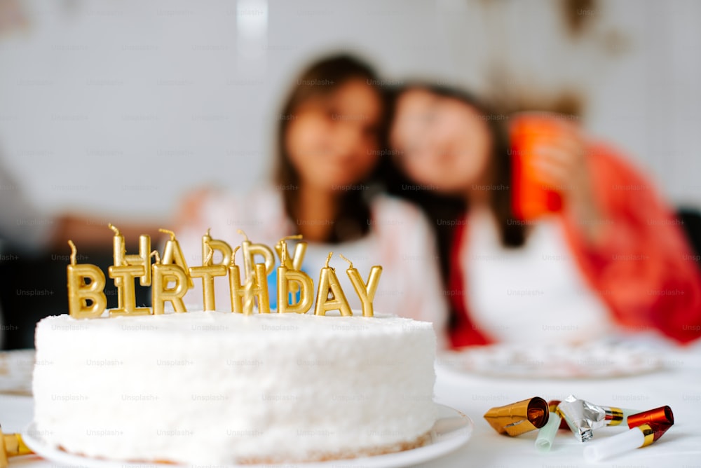 Una pareja besándose detrás de un pastel de cumpleaños con velas