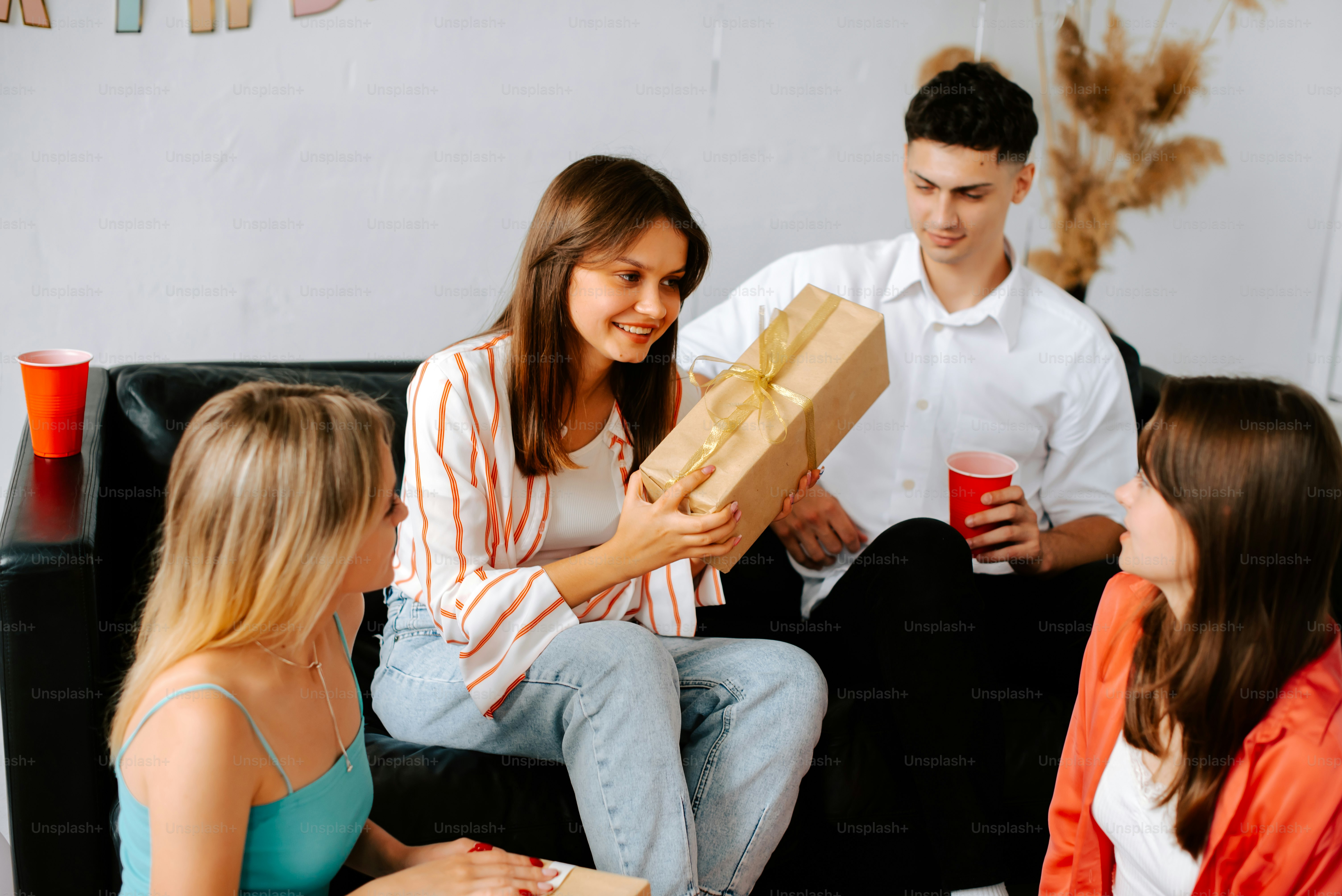 um grupo de pessoas sentadas em um sofá segurando presentes