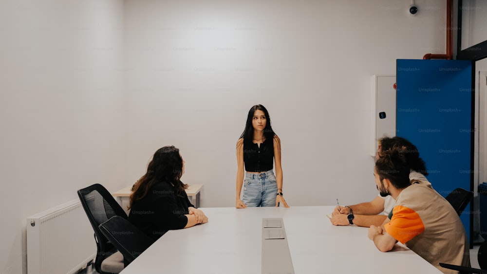 a group of people sitting around a white table