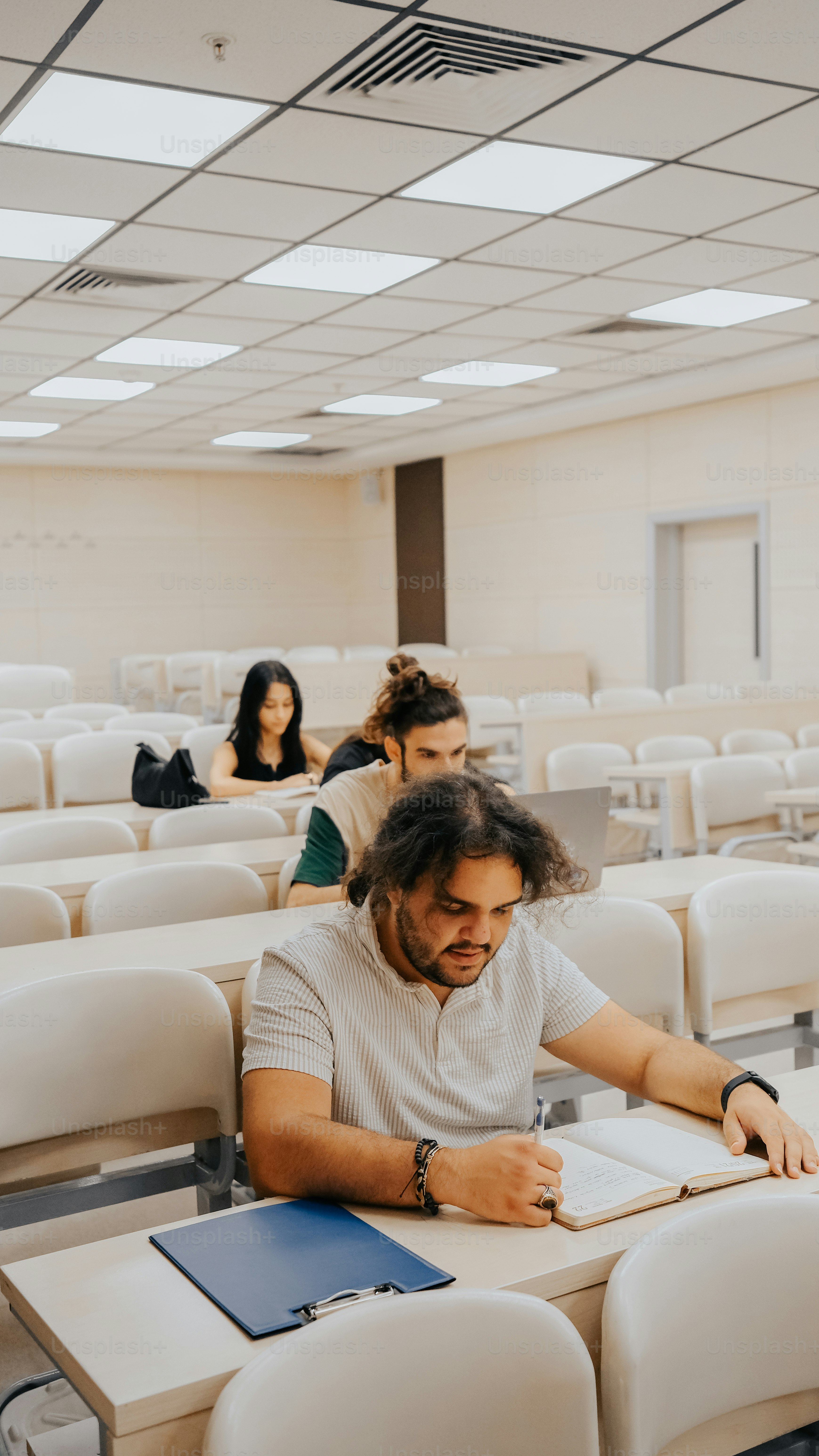 ノートを前にしてテーブルに座っている男