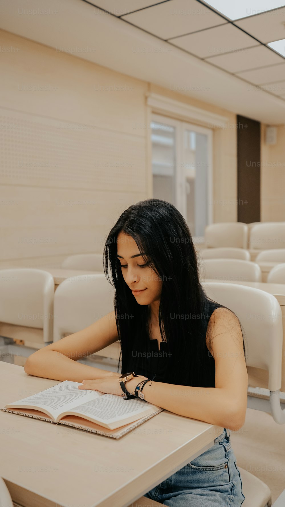 una donna seduta a un tavolo che legge un libro