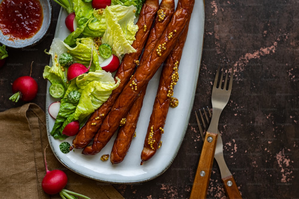 a plate of food that includes lettuce, carrots and ketchup