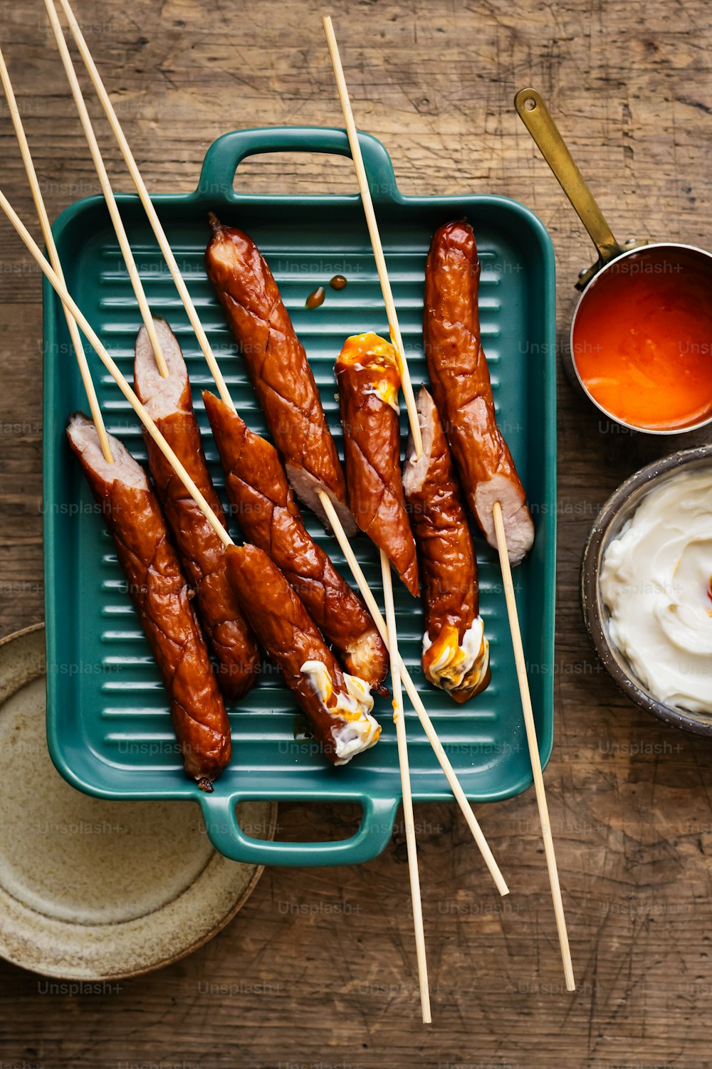 a tray with skewers of food and dip