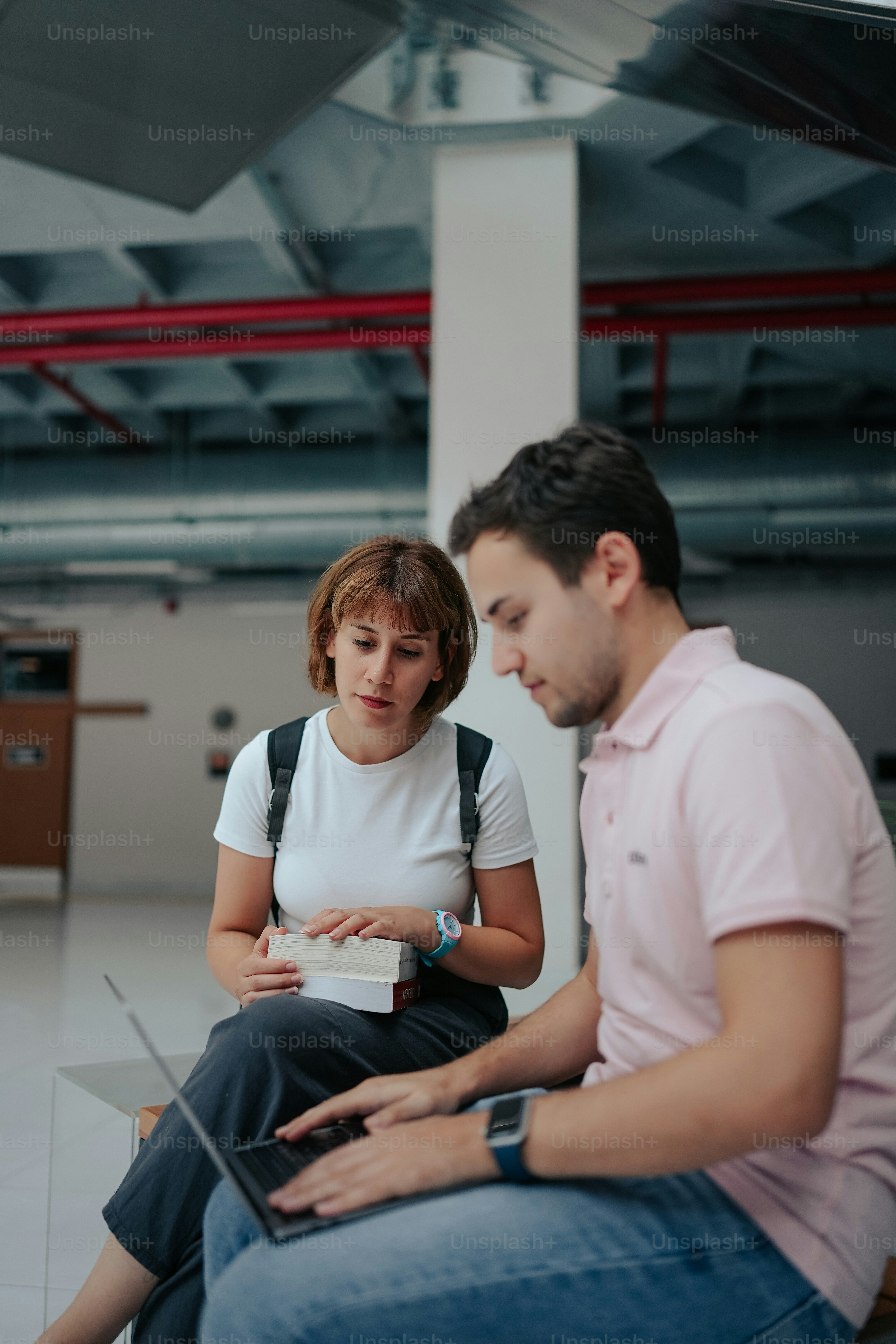 a man sitting next to a woman on a laptop