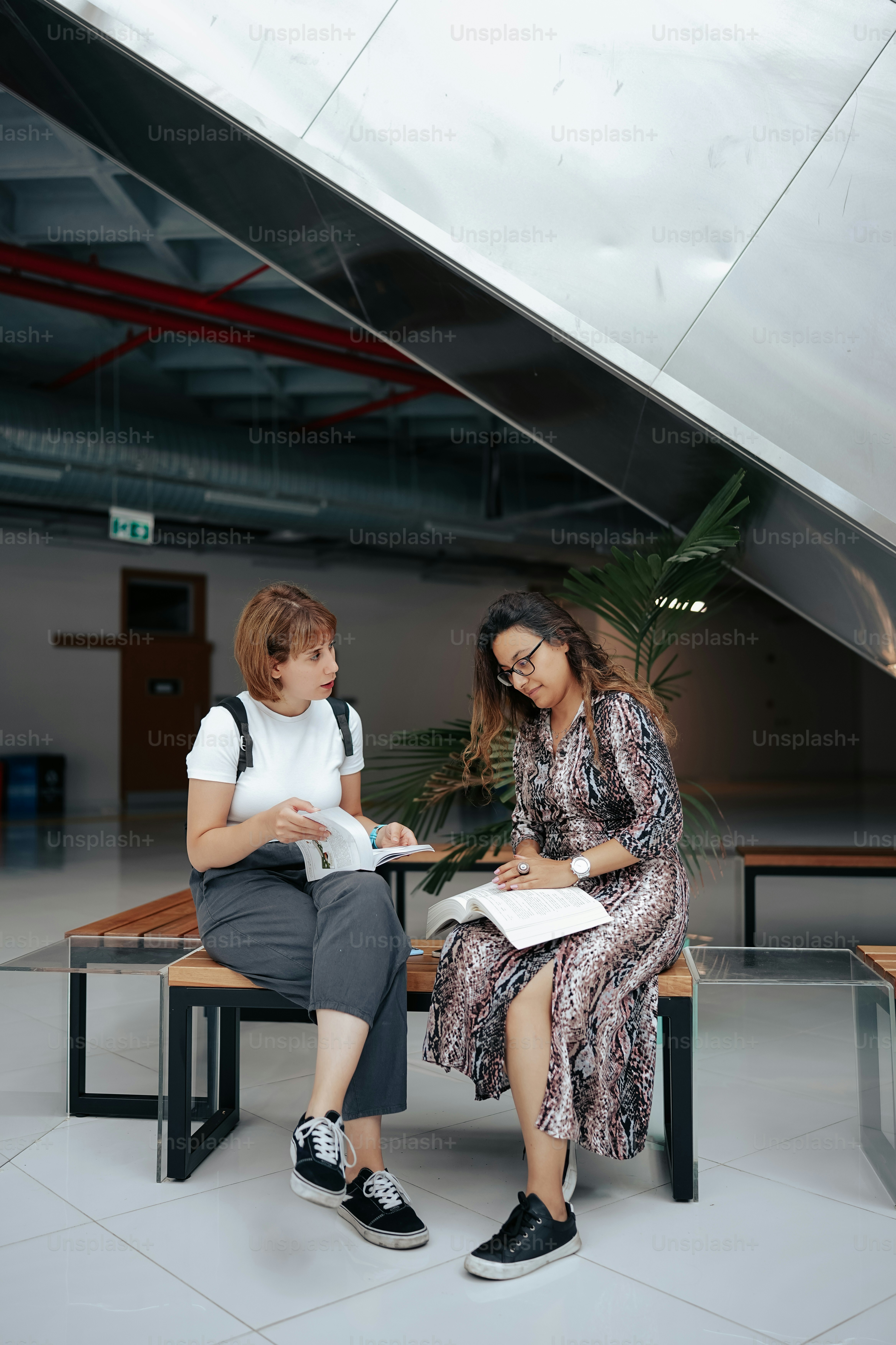 Una mujer sentada en un banco junto a otra mujer foto – Imagen de ...