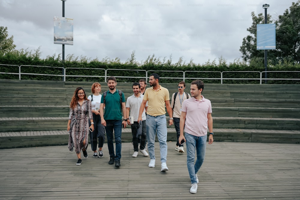 a group of people walking down a wooden walkway