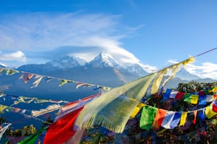Un mazzo di bandiere colorate sono appese di fronte a una montagna