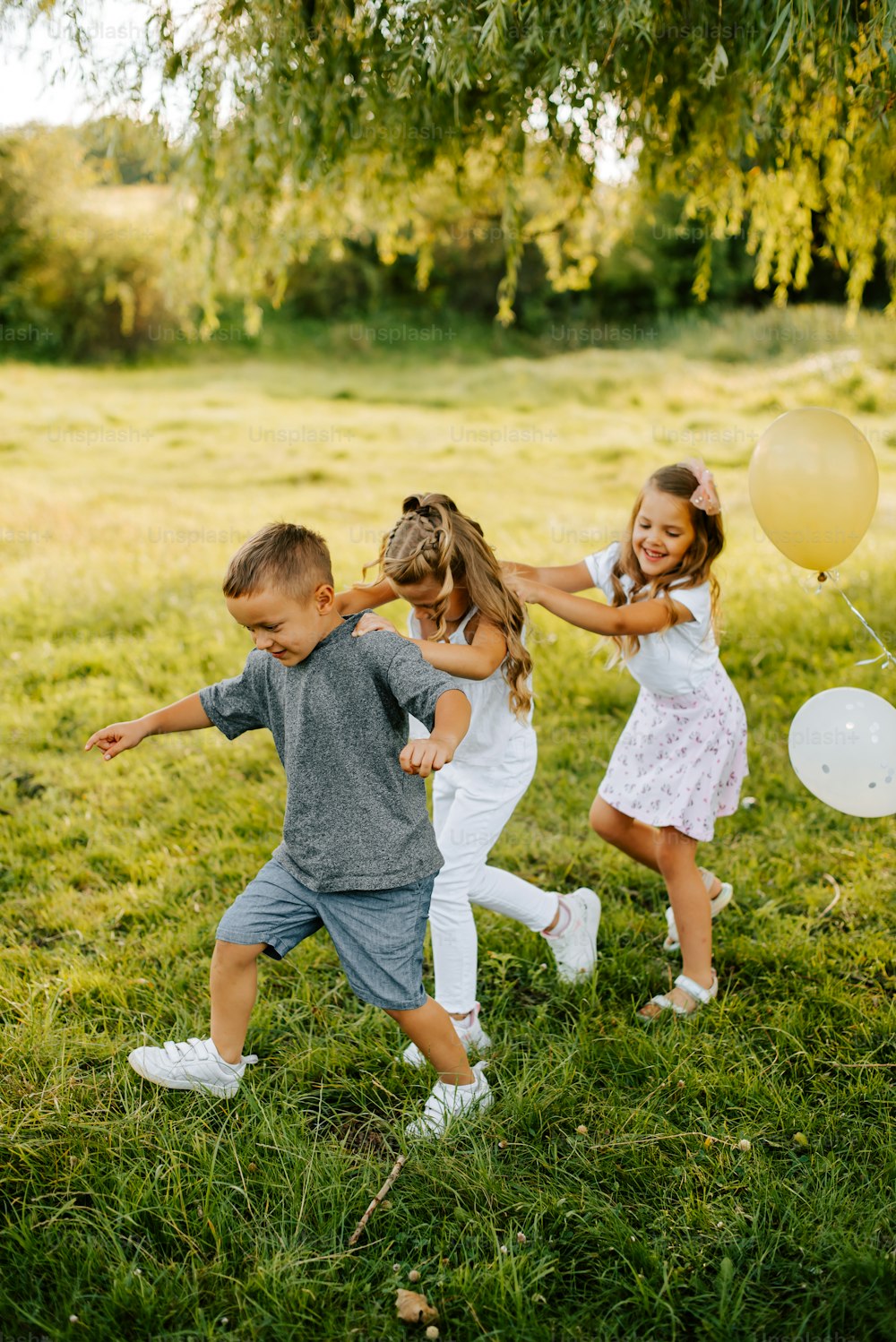 a group of young children playing with balloons