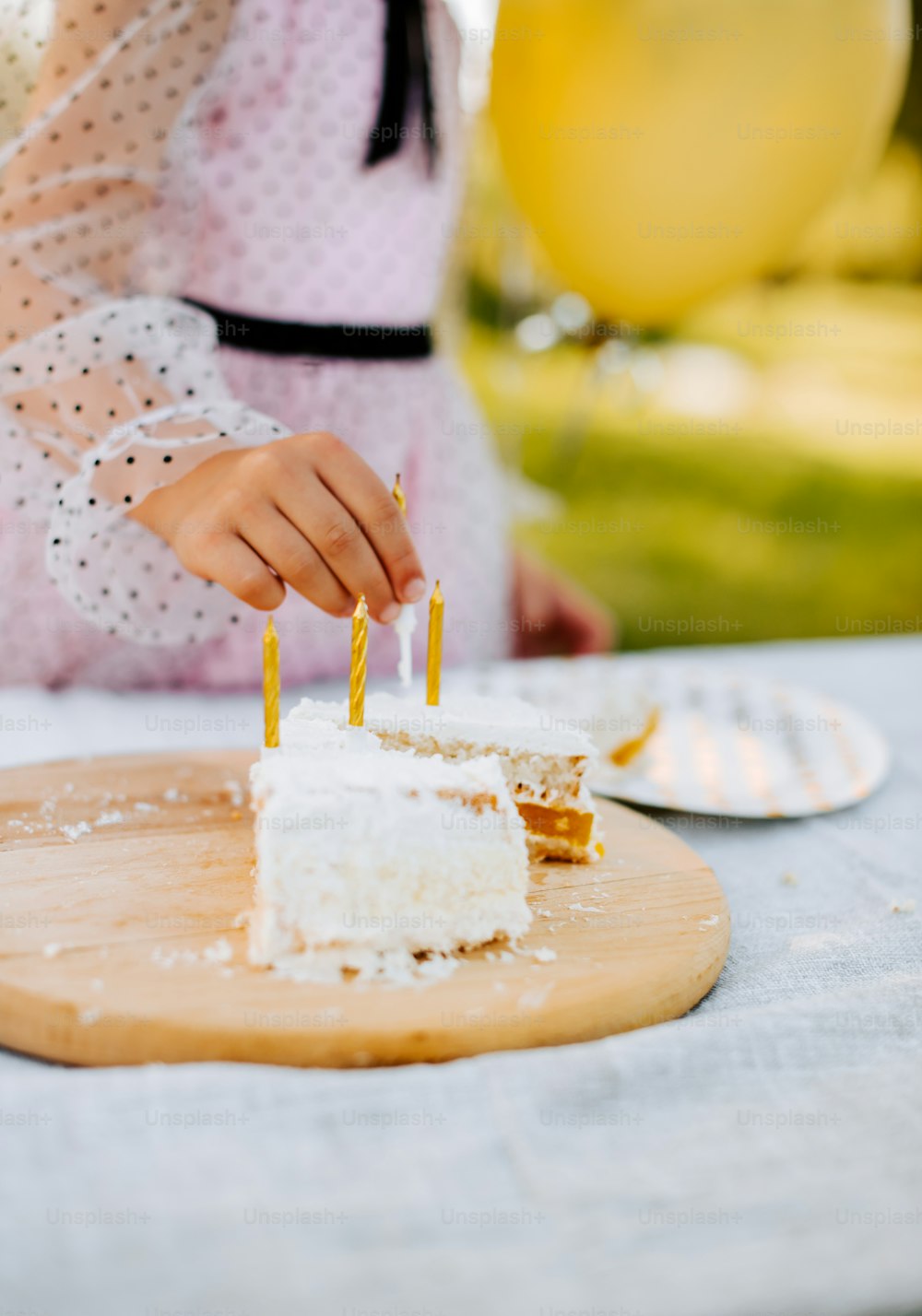 a person lighting candles on a piece of cake