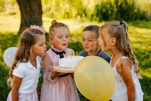 a group of little girls standing around a cake
