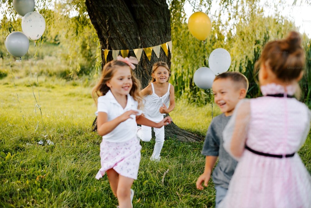 a group of children playing with balloons in a field
